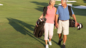 Couple walking happily on the golf course.