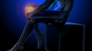 Silhouette of a man holding his knee. The knee is highlighted in red, indicating pain.
