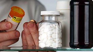 A person examining pill bottles.