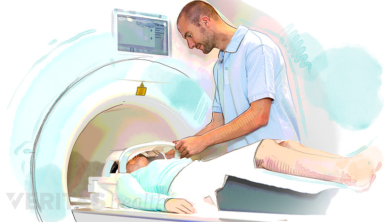 Patient entering an MRI scanner with technician.