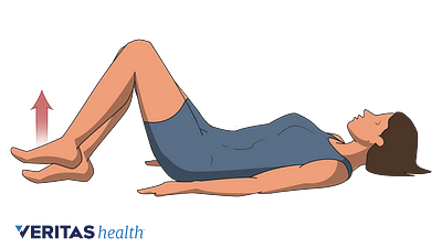 Persona tendida en el suelo con las rodillas dobladas, realizando el ejercicio de marcha tumbada con gancho