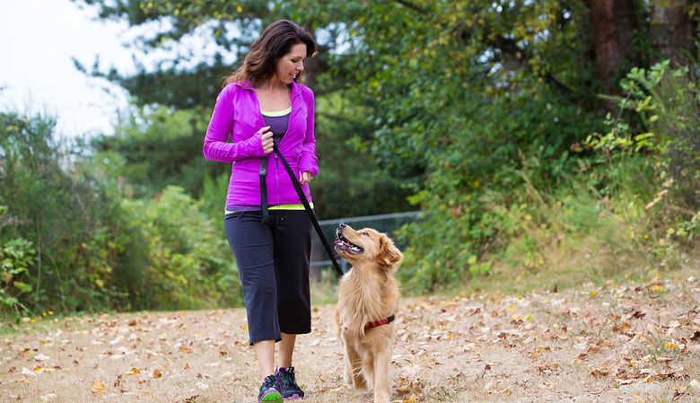 Woman walking her dog on a trail