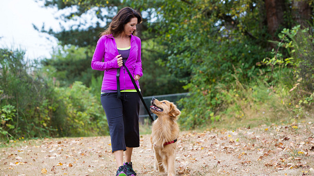 Woman walking her dog on a trail