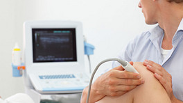 Technician administering an ultrasound on a patient&#039;s knee.