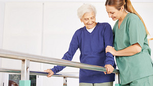 Physical therapist helping a patient walk