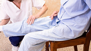 Physical therapist working with a patient&#039;s knee