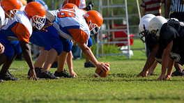Two teams playing football at the line of scrimmage