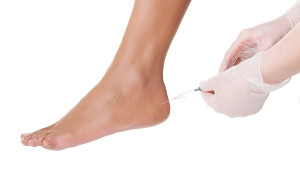Patient receiving an injection in the achilles heel