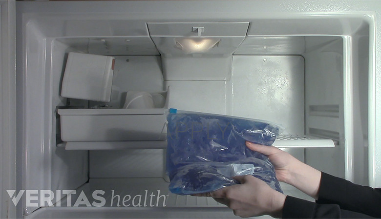 Woman taking an ice pack out of the freezer.