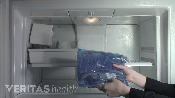 Woman grabbing ice pack out of freezer