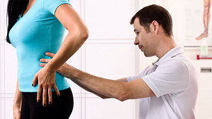 Chiropractor manipulating a patient&#039;s lower back