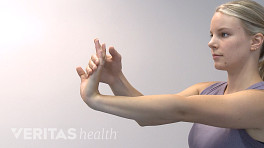 Profile view of woman doing a wrist flexor stretch.