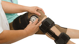 Physical therapist adjusting knee brace