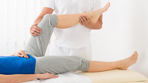 Physical therapist working with a patient&#039;s knee