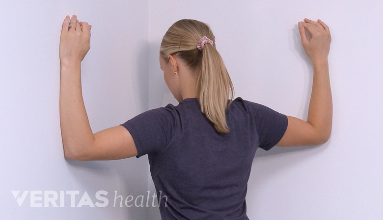 Therapist showing corner stretch exercise.