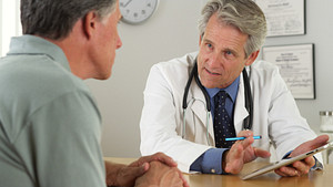 Doctor and male patient discussing information on an iPad
