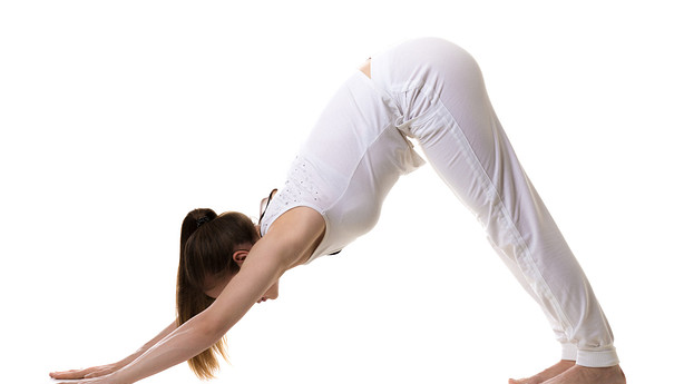 Woman performing downward dog pose yoga stretch.