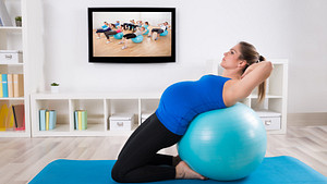 Pregnant woman performing exercises on an exercise ball.