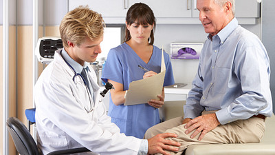 Doctor checking senior patient&#039;s knee