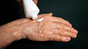Applying topical pain reliever to right hand