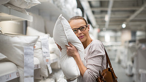 Woman squeezing a pillow in a store