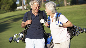 Couple walking happily on the golf course.