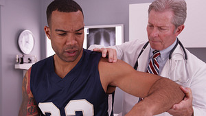 Patient&#039;s shoulder examined by doctor