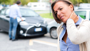 Woman grabbing her neck after car accident.