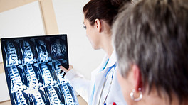 Doctor examining scans of a patient&#039;s spine.