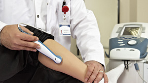 A doctor doing an ultrasound on a lower leg