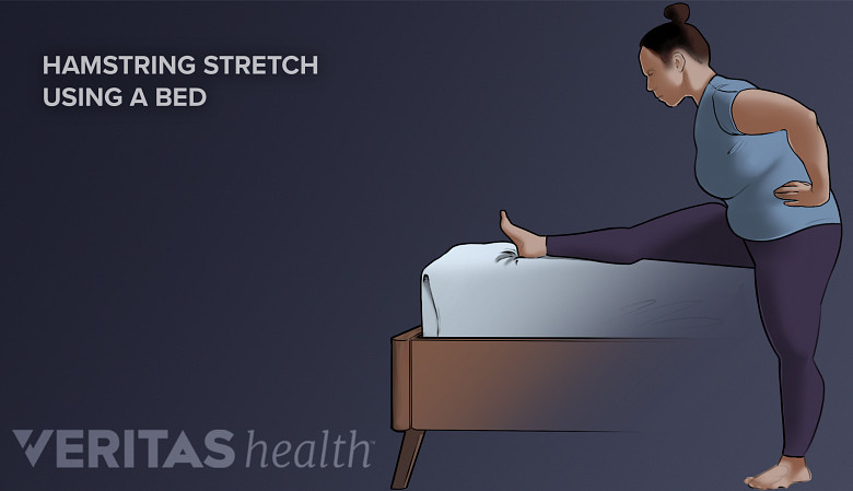 Person doing a hamstring stretch on the bed.