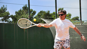 Man hitting a tennis ball on his forehand side.