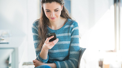 Young woman sitting using her smartphone