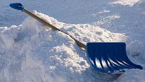 Snow shovel lying in the snow.