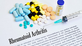 A print out of rheumatoid arthritis definition with pills and biologics laid on the tdesk