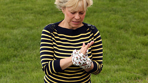 Woman gardening and holding her hand in pain.