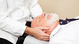 Chiropractor adjusting an older man&#039;s neck