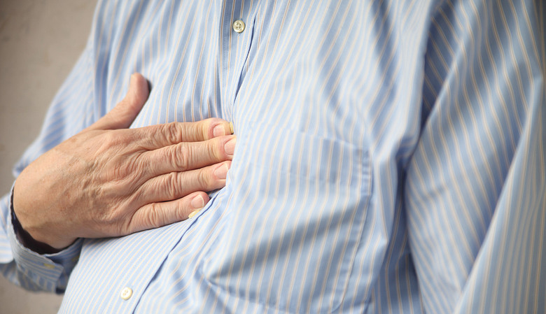 Man holding chest with heartburn