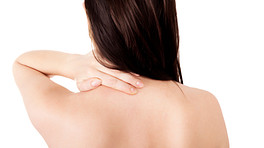Posterior view of woman massaging upper back and neck.