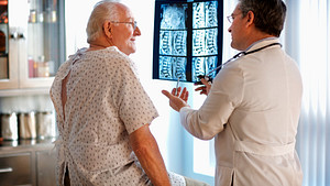 A doctor reviewing an xray of a patient spine with the patient