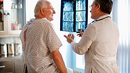 A doctor reviewing an xray of a patient spine with the patient