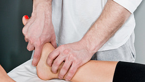 Examining a patient&#039;s ankle.
