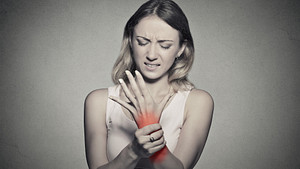 Woman grabbing wrist in pain.