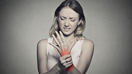 Woman grabbing wrist in pain.