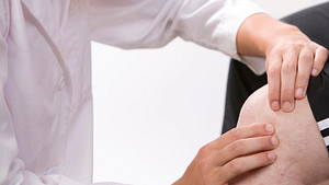Physician examining patient&#039;s knee