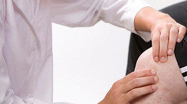 Physical therapist examining a patient&#039;s knee