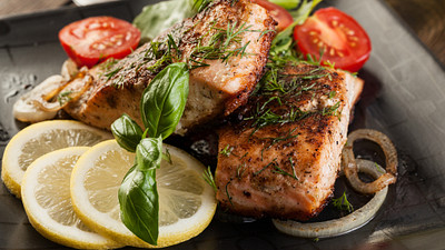Plate of salmon with tomatoes and lemon slices