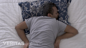 Man sleeping on his stomach in an awkward position