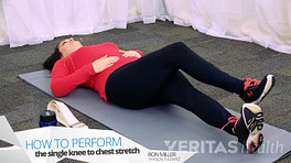 Woman lying on their back how to perform the single knee to chest stretch.