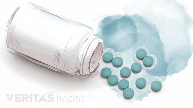 Illustration of pill bottle on it&#039;s side with blue pills spilling out.